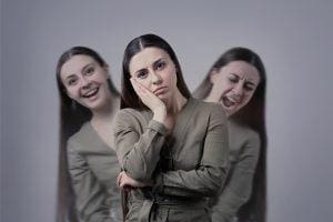 Three faces - one screaming, one sad, and another normal. A depiction of how a person with bipolar thinks.